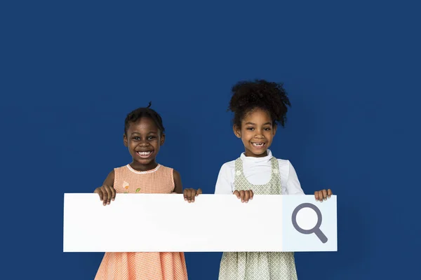 Meninas sorrindo e segurando em branco — Fotografia de Stock