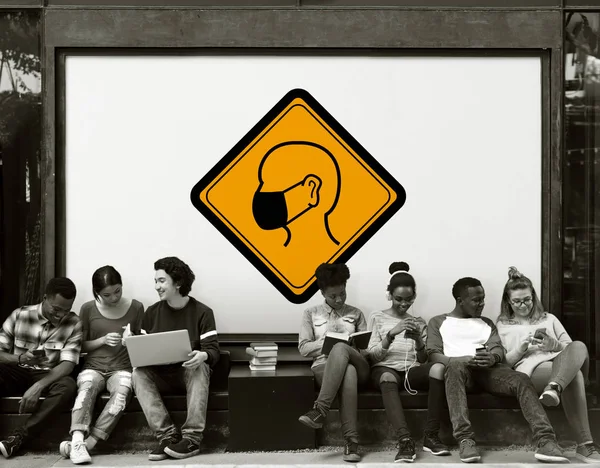 Jóvenes estudiantes sentados cerca de la pancarta —  Fotos de Stock