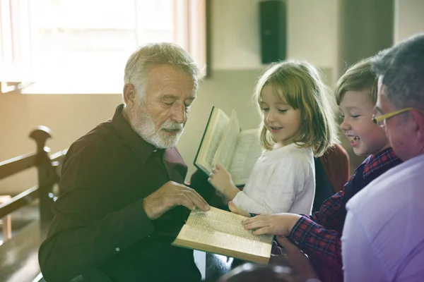Священник показывает Библию детям — стоковое фото