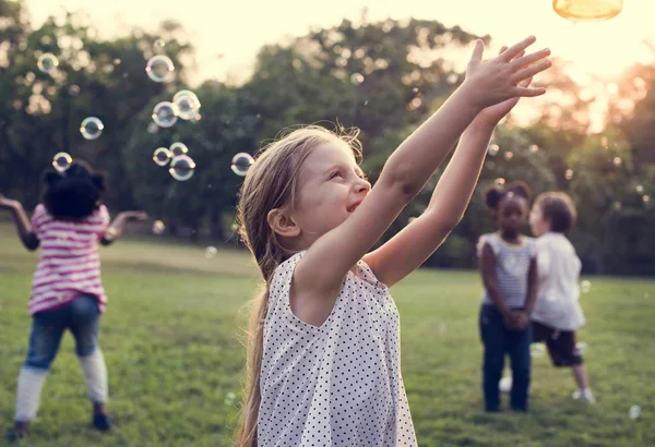 Menina brincando com bolhas de sabão — Fotografia de Stock