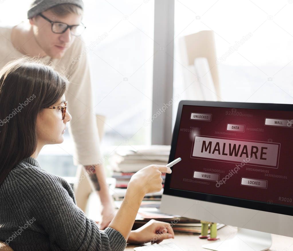 People looking on computer screen with text: Malware