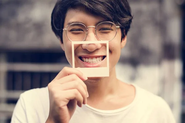 Hombre cubriendo la boca con tarjeta fotográfica —  Fotos de Stock