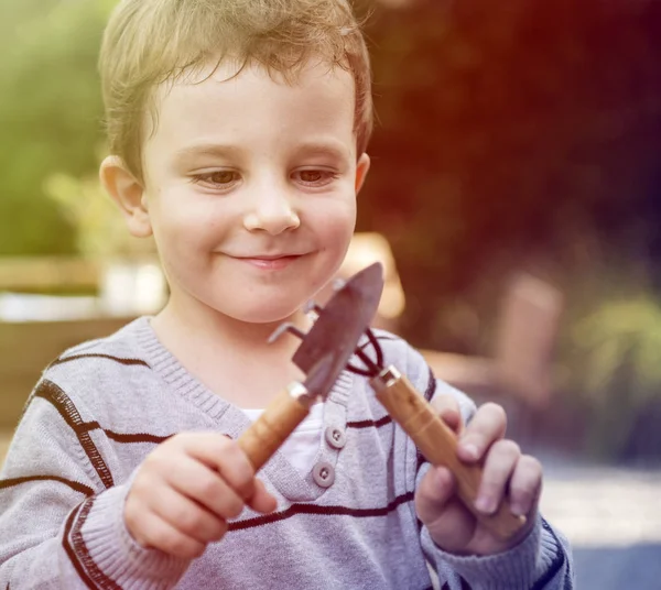 Niño jugando con herramientas de jardinería —  Fotos de Stock