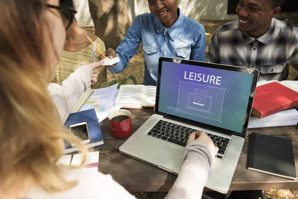 Studenti seduti a tavola con libri e laptop — Foto Stock