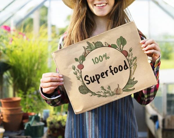 Frau hält Transparent im Gewächshaus — Stockfoto