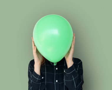 Yeşil balon ile yüz kapsayan kadın