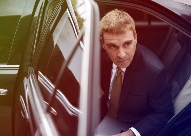 İşadamı arabada oturan takım elbiseli