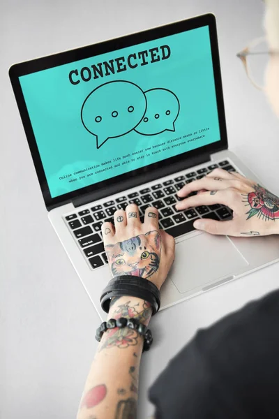 Tatuerade person att skriva på laptop. — Stockfoto