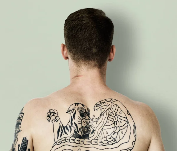 Мужчина с татуировкой на голой спине — стоковое фото