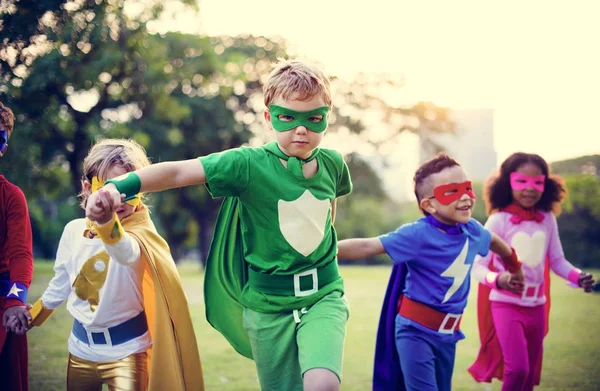 Діти в костюмах супергероїв бігають — стокове фото