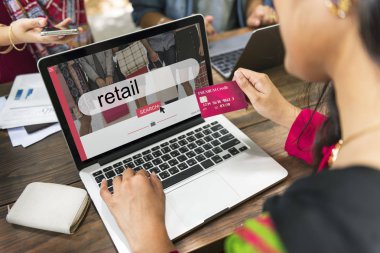 Bilgisayarı ve kredi kartı olan bir kadın.