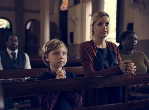 Familie betet in der Kirche — Stockfoto