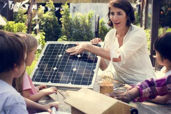 Leraar kinderen vertellen over zonne-energie pannel — Stockfoto