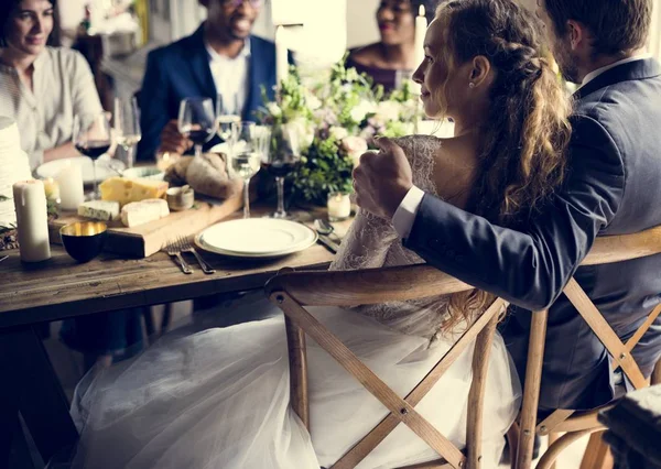 Mensen vieren bruiloft aan tafel — Stockfoto