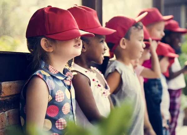 Pequeños estudiantes con gorras rojas — Foto de Stock