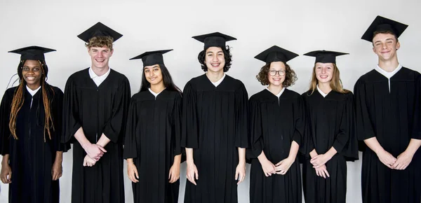 Estudantes em bonés e roupões de graduação — Fotografia de Stock