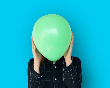Yeşil balon ile yüz kapsayan kadın