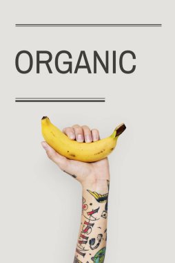 Dövmeli kişi holding muz.