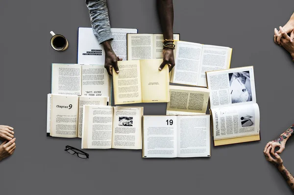 Hände am Tisch mit vielen Büchern — Stockfoto