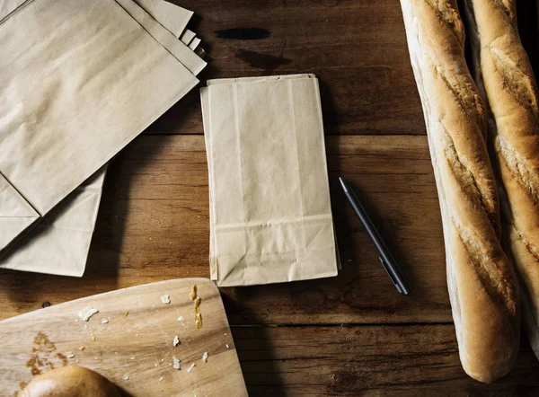 Ξύλινο Τραπέζι Ψωμί Και Χαρτί Τσάντα — Φωτογραφία Αρχείου