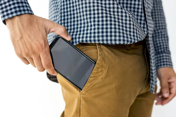 Рука положить смартфон в карман — стоковое фото