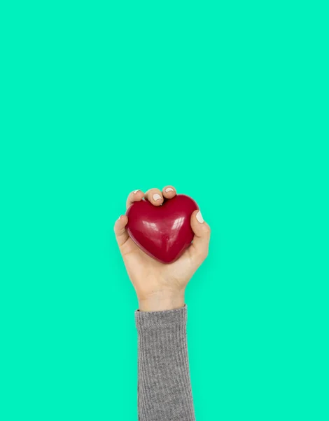 Hand hält rotes Herzspielzeug — Stockfoto