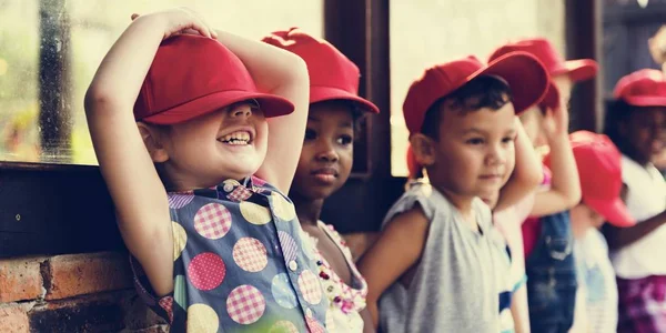 Маленькие студенты в красных кепках — стоковое фото
