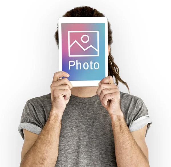 Hombre celebración de la tableta digital que cubre la cara —  Fotos de Stock