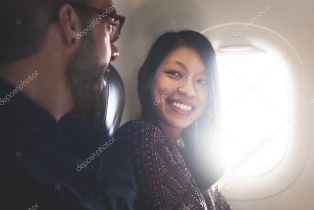 man and woman in front of airplane porthole