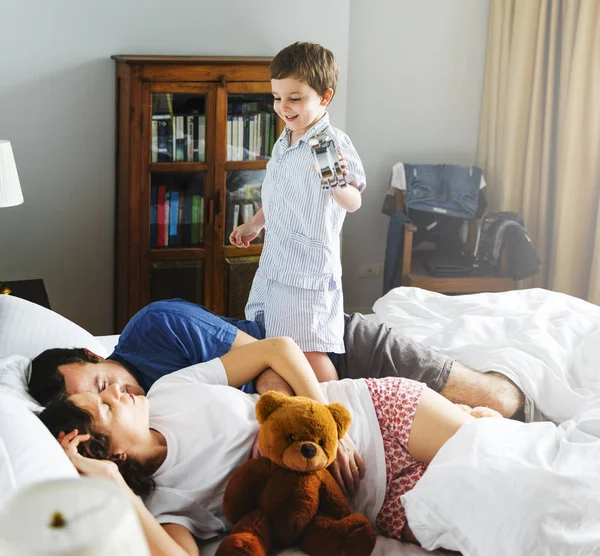 Chico despierto en dormitorio con padres — Foto de Stock