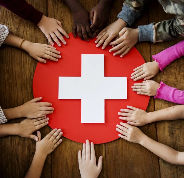 Manos en la cruz roja médica — Foto de Stock