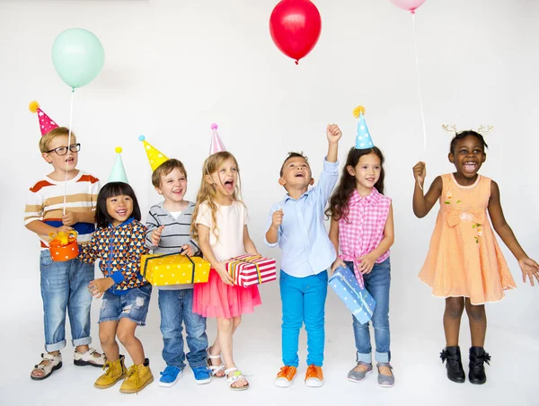 Niños en sombreros de fiesta con regalos —  Fotos de Stock