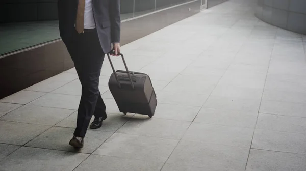 Бизнесмен в костюме ходит с багажом — стоковое фото