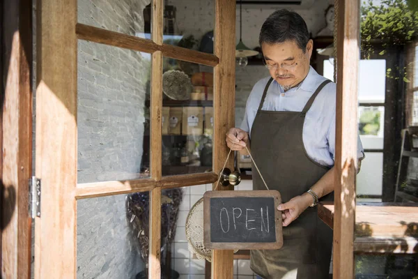 Man hanging wooden open sign on the window — Stock Photo, Image