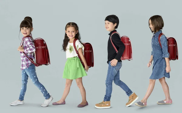 Crianças andando com mochilas — Fotografia de Stock