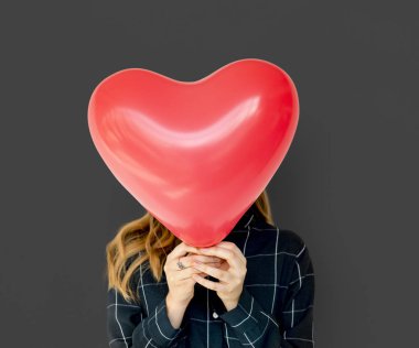 Kalp balon ile yüz kapsayan kadın