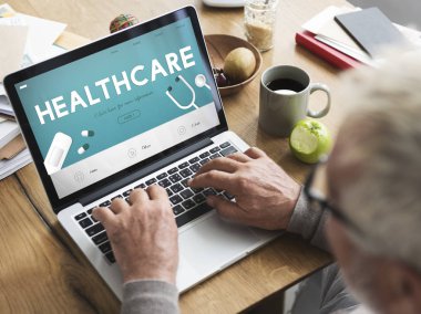 Dizüstü bilgisayarda çalışan kıdemli adam.