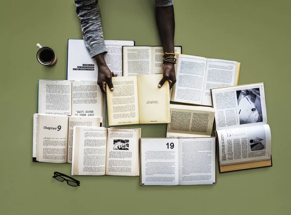 Händerna på bordet med många böcker — Stockfoto