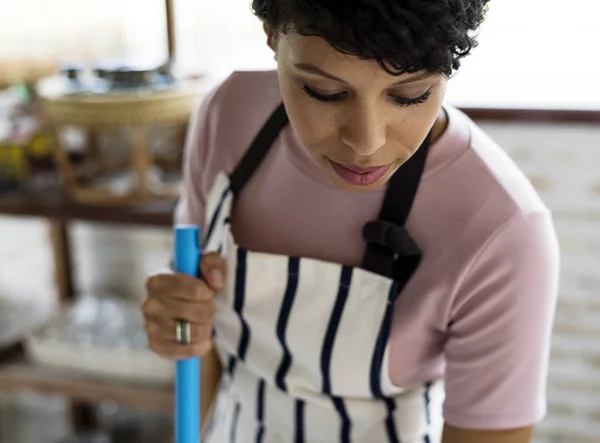 Afrikaanse vrouw in schort werken in shop — Stockfoto