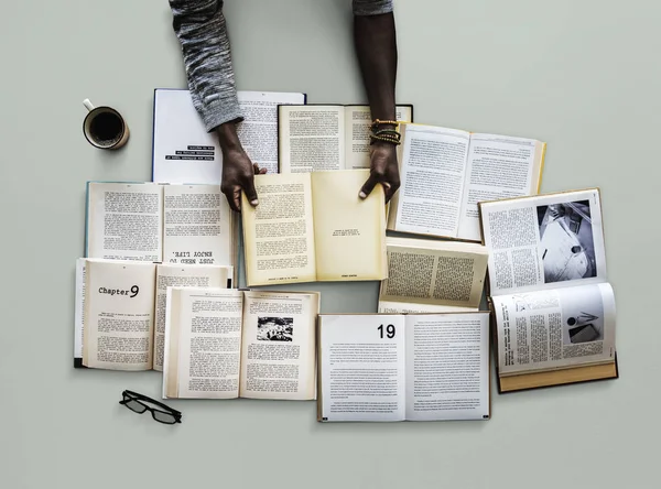 Händerna på bordet med många böcker — Stockfoto