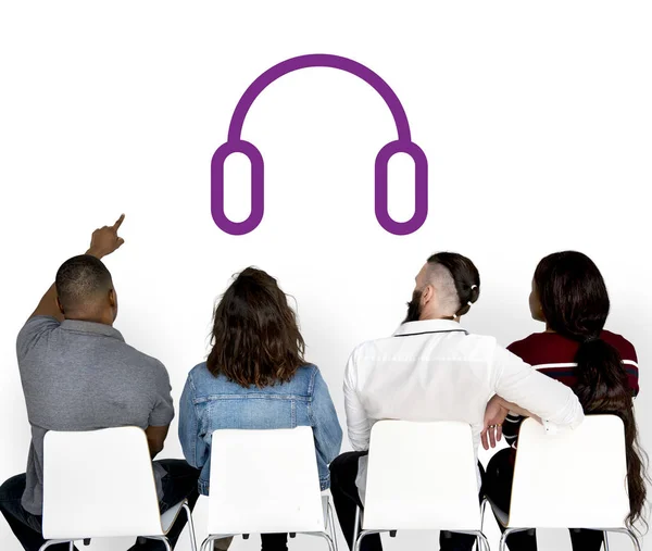 People sitting on chairs and looking at wall — Stock Photo, Image