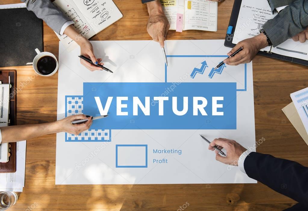 Hands of business people over wooden table and banner with Venture