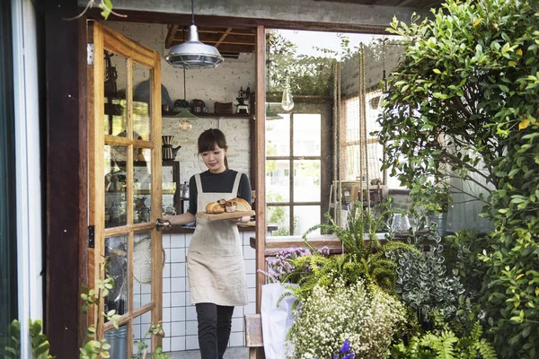 Woman carrying bread pastry to customer — Stock Photo, Image