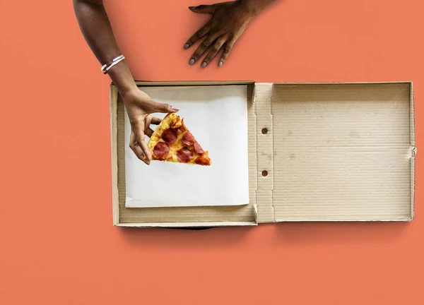 Vrouwelijke hand bedrijf pizza — Stockfoto