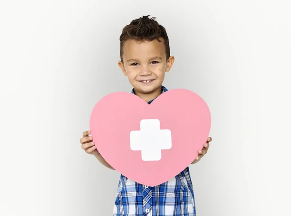 Jongen bedrijf hart met kruis — Stockfoto