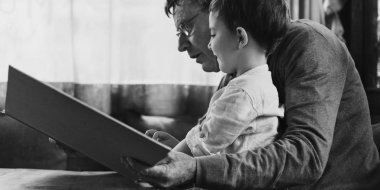 Büyükbaba ve torun kitap okuyor.