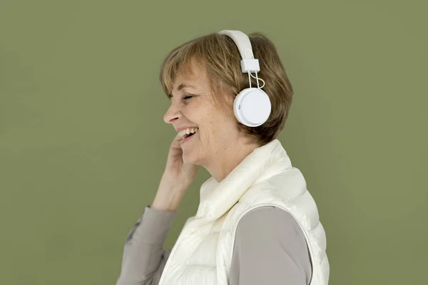 Starsza kobieta słuchania muzyki w słuchawkach — Zdjęcie stockowe