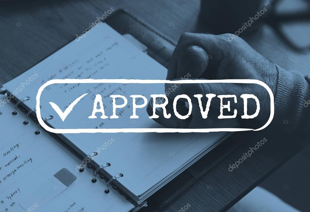 Hand putting approved stamp on paper document
