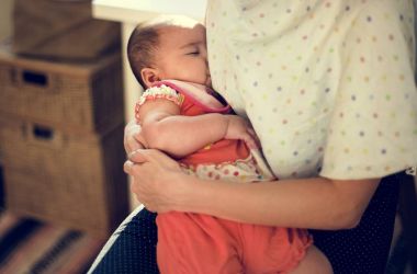 Anne yeni doğan bebeği besliyor.