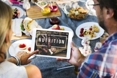 Tablet ve sahip piknik kullanarak çift